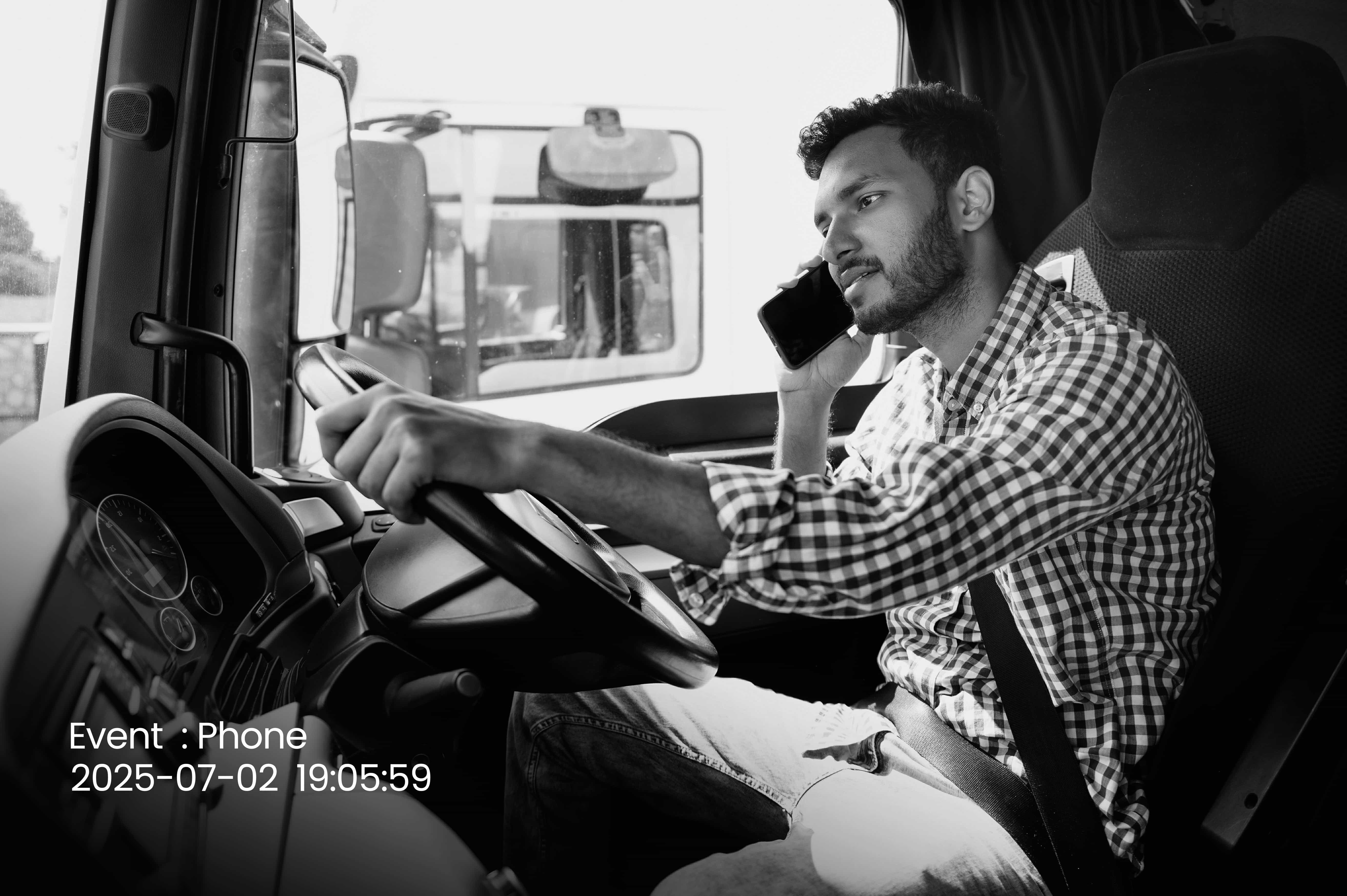 In-cab camera still documenting a driver using a phone while driving